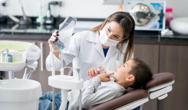  Dentista pediátrico en Absolute Dental mostrando radiografía infantil